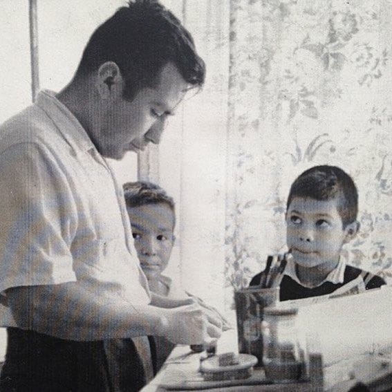 Foto antigua de Jazzamoart y su hermano mirando a su padre.